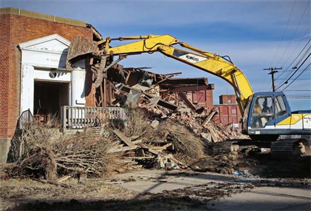 US mill that started Buffett's empire razed An excavator operator demolishes the entrance to the former headquarters of the Berkshire Hathaway mill (Photo: AP)