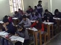 A tenth student who is giving board exams, writes with leg