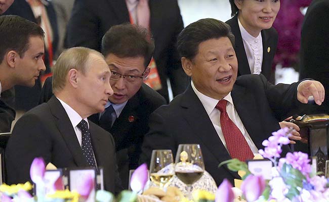 President Xi Jinping (front R) speaks to Russian President Vladimir Putin (front L) during a welcome dinner. (Reuters)