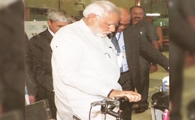 Prime Minister Narendra Modi, during his visit to the centre, examines the cycle fitted with a water purifier.