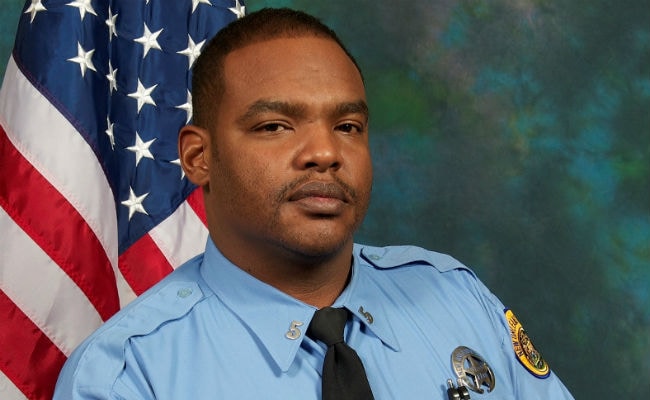 Hunt After Man Fatally Shoots US Officer in Police Car