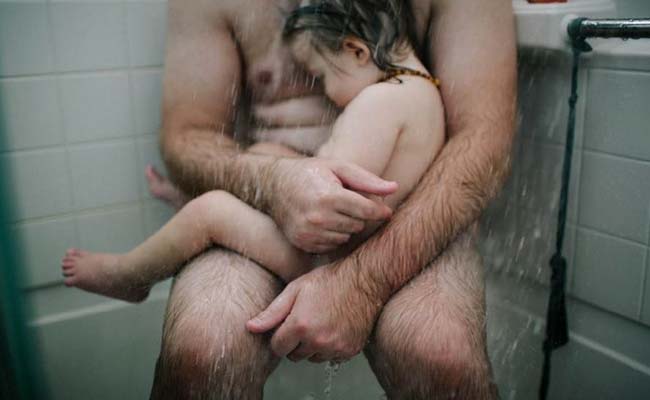 Facebook Pic of Dad Cradling Baby in Shower Goes Viral, Prompts Debate