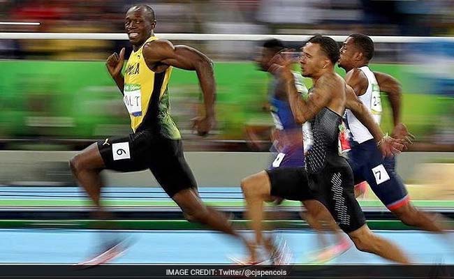 Usain Bolt performs his trademark pose in cheerful company