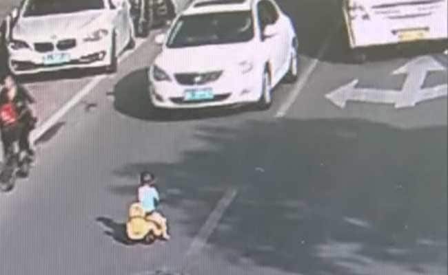 ट्रैफिक वाली सड़क पर टॉय कार लेकर उतरे बच्‍चे की पुलिस अफसर ने बचाई जान, देखें वीडियो...