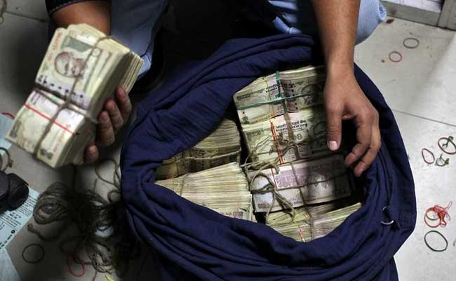 Black Businessman holding black bag full of US dollar notes