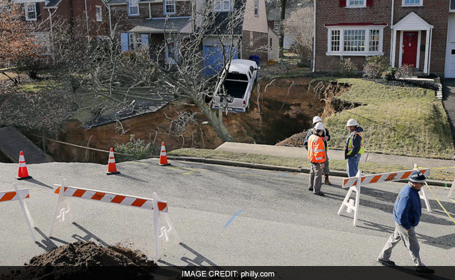 A Sinkhole That Swallowed Two Yards Leaves Truck Dangling On Edge