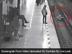 Thrilling Footage Shows Man Jumping On Train Tracks To Save Little Boy