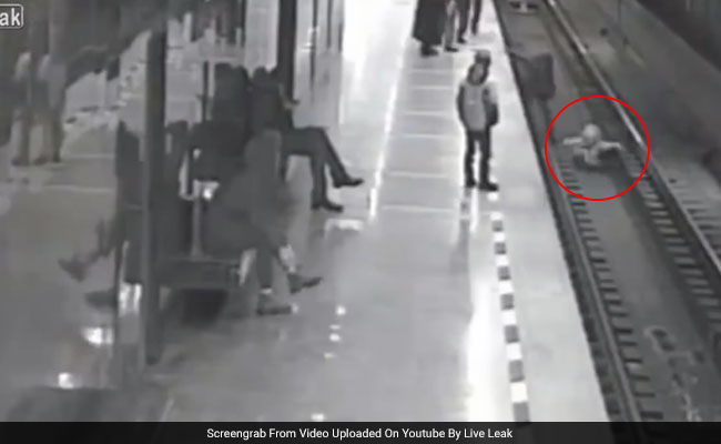 Thrilling Footage Shows Man Jumping On Train Tracks To Save Little Boy