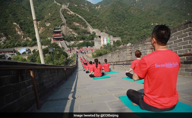 Indian And Chinese Yoga Enthusiasts Practice Poses At Great Wall Of China