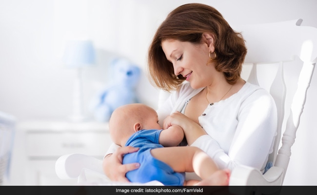 Mother giving store milk to baby