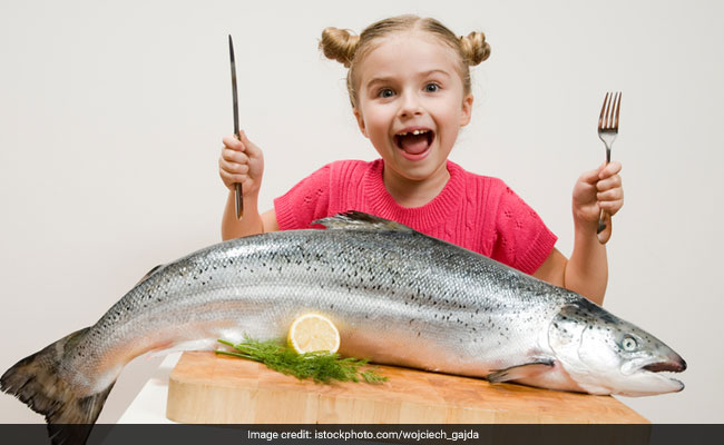 child eating fish