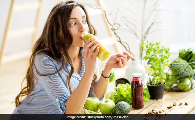 Fitness woman drinking a healthy green smoothie juice for a detox