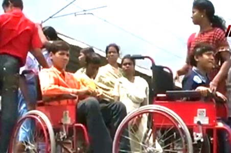People in wheelchairs placed on train tracks