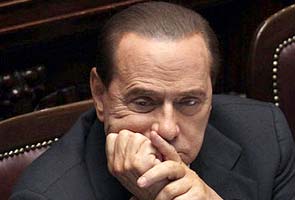 Berlusconi returns to dock, laughs off sex crime trial