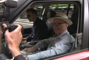 In Range Rover, Murdoch seen with last edition of his paper