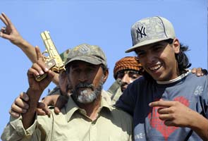 Young men who found Gaddafi have his golden gun, satellite phone