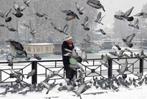 Heavy snow blocks roads and burries homes in Kashmir