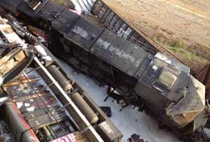 US highway buckles after rail cars hit overpass