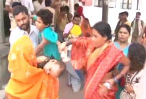 Panicked parents carry children poisoned by mid-day meals out of hospital