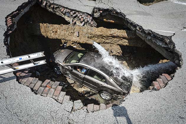 Ohio sinkhole swallows car; driver climbs ladder 