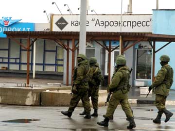 Kalashnikovs in hand, unidentified men patrol Ukraine's Crimea airport