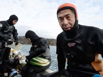 Widower dives tsunami waters to bring wife home