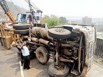 Close shave for couple as truck overturns inches from their home