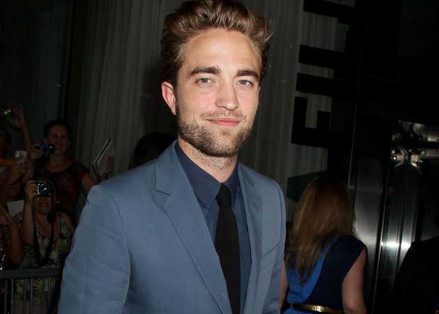 Robert Pattinson "all smiles" at <i>Cosmopolis</i> premiere