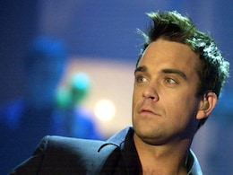 Robbie Williams performs with naked models Robbie Williams performs with naked models