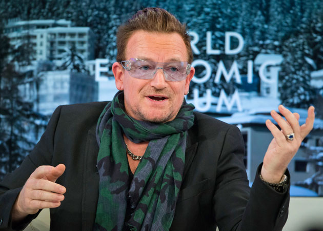 Bono and family pray together on a bed