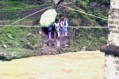 उत्तराखंड में बाढ़ : उफनती नदी के ऊपर से ट्रॉली में बैठकर स्कूल जा रहे बच्चे उत्तराखंड में बाढ़ : उफनती नदी के ऊपर से ट्रॉली में बैठकर स्कूल जा रहे बच्चे
