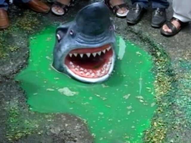 दिल्ली : गड्ढों में मगरमच्छ और शार्क के पुतले बनाकर कांग्रेस ने किया प्रदर्शन